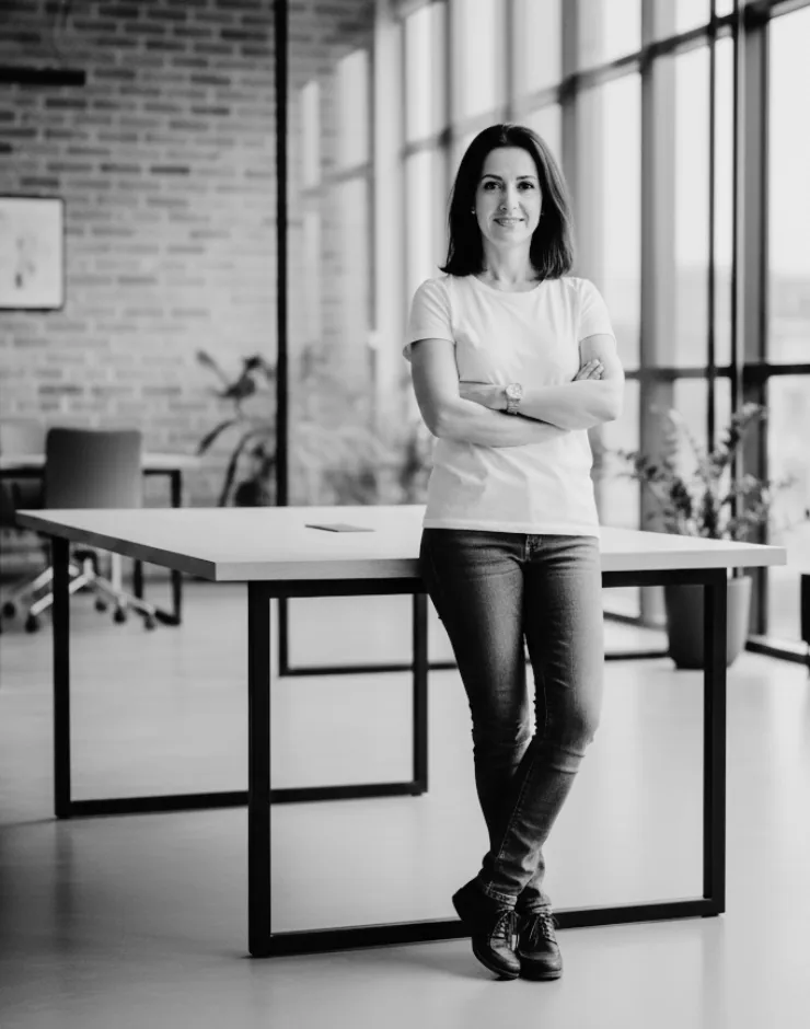Sofia Martí, Teammember and Chief Visionary Officer of FlowMotive Vision, leaning on a table in the office
